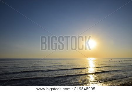 Sea sunset. People bathe in the evening at sunset in the sea