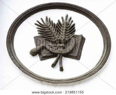 bunch of mown wheat ears with vintage handmade reaper hook sickle on white background