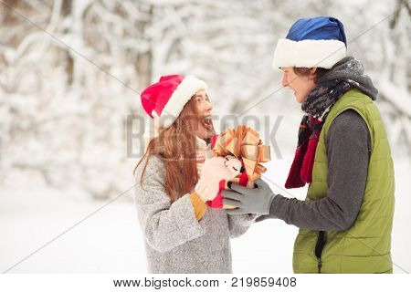 A young beautiful lady is surprised. She got present from her belover.