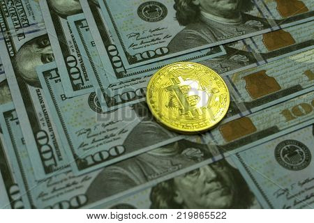 Coins bitcoin on a background of 100 American dollars close-up