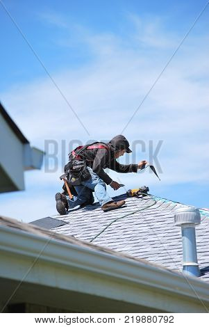 CASPER, WY. MAY 22, 2013. CIRCA: Male roofers at work outdoors on top of a housing project roof.
