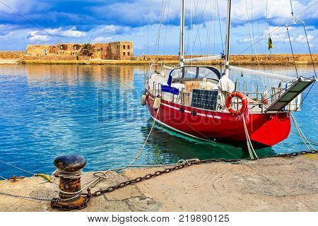 red sailing boat in old town of Chania, Crete islad, Greece