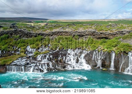 Hraunfossar waterfalls - Western Iceland. The water seems to appear from the lava but is a spring that surges through the ground and runs in rapids into the Hvita River.