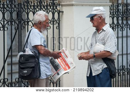 Havana, Cuba, July 2014 - Two cubans with the granma newspaper at havana