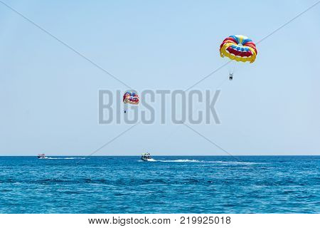 Two speed boats with people flying on parasailing parachute (RHODES GREECE)