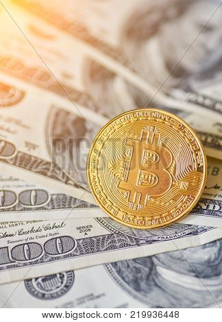 Golden metal bitcoin on dollar bills background