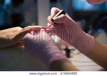 master in the beauty salon getting a manicure client