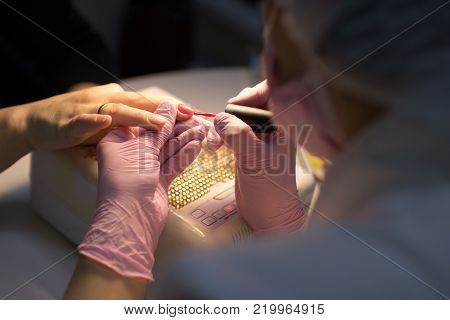 master in the beauty salon getting a manicure client