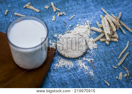 Close Up Of Ayurvedic Herb   Satavari,asparagus Racemosus With Its Powder And Root With Milk Glass.