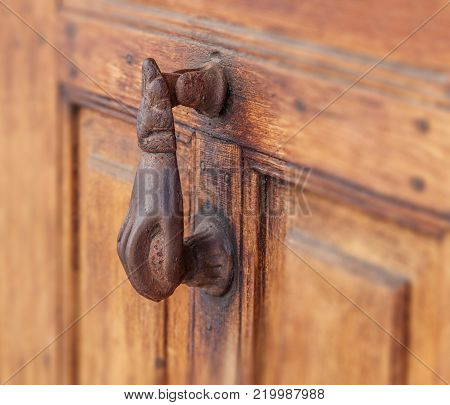 Metal antique doorhandle on old rusty brown door close view