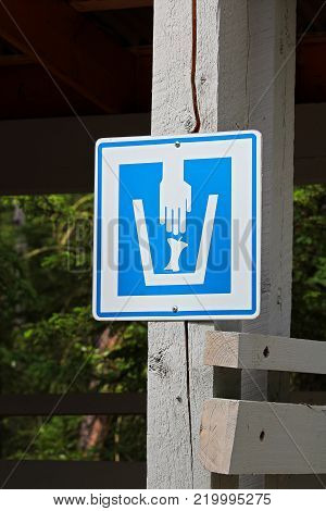 Closeup of a composting waster sign on a wooden post.