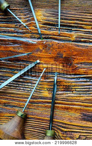 Different gravers for jewelry on a wooden background