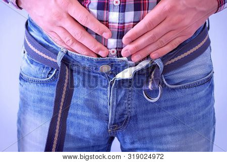 Man With Buckled Jeans And Belt. He Is Stroking And Touching His Stomach After Heavy Dinner. Waist C