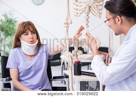 Young woman in wheel-chair visiting male doctor 