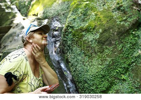 Woman Washing Herself With Water From Stream