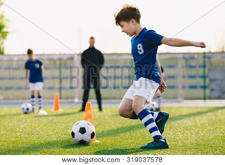 Children Training Football Dribbling In A Field. Kids Running The Ball. Players Develop Soccer Dribb