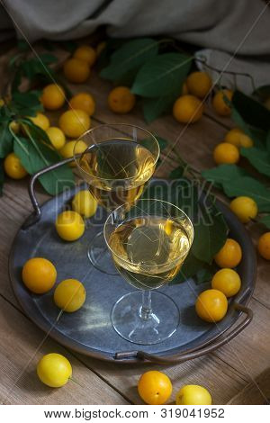 Cherry Plum Liqueur In Small Glasses And Cherry Plum On A Wooden Background. Rustic Style.