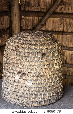 Bokrijk, Belgium - June 27, 2019: Closeup Of Classic Large Yellowish-brown Straw Beehive Set Under A