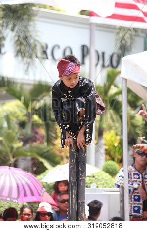 Davao City, Philippines-august 2014: A Boy Balances Himself On Bamboos Poles During A Performance At