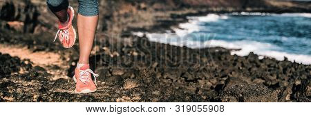 Runner running shoes woman exercise on trail path jogging outside by ocean shore banner panoramic background. Female thlete training.