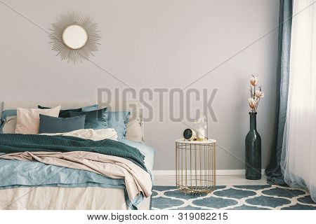 Clock And Flower In Fancy Vase On Nightstand Table Next To King Size Bedroom With Emerald Green And