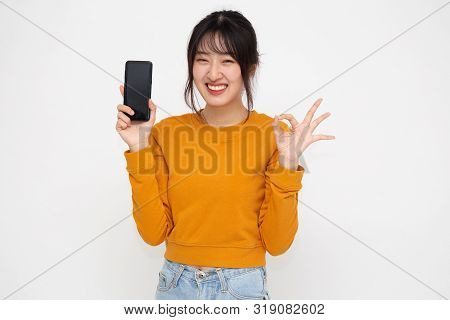 Portrait Of Beautiful Asian Teenager Wowan Showing Or Presenting Mobile Phone Application On Hand An