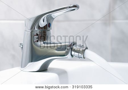 Close Up Of The Mixer Tap Of A Bidet With Running Water. The Bidet Was Invented In France In The 170