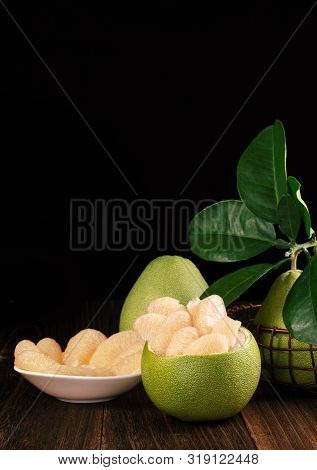 Fresh Peeled Pomelo, Grapefruit, Shaddock With Green Leaves On Dark Wooden Plank Table. Seasonal Fru