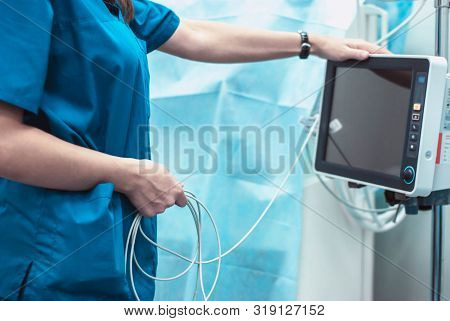 The Doctor Includes An Apparatus For Monitoring The Vital Functions Of The Patient. A Girl In A Surg