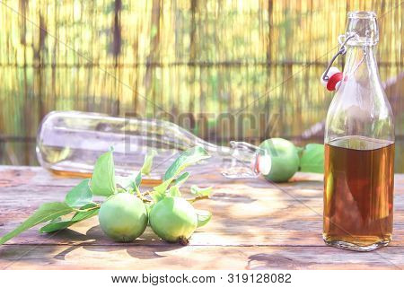 Apple Cider Poured Into Bottles. Glasses Filled With Apple Cider Vinegar Stand On An Old Vintage Tab