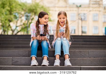 Portrait Of Two Nice Attractive Lovely Cute Cheerful Cheery Amazed Astonished Pre-teen Girls Using O