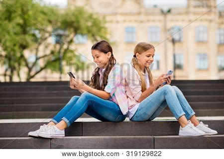 Profile Side View Of Two Nice Attractive Lovely Cheerful Cheery Focused Pre-teen Girls Chatting Onli