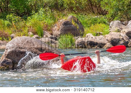 Playboating. A Man Sitting In A Kayak With Oars In His Hands Performs Exercises On The Water. Kayaki