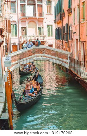 Venice, Italy - May 25, 2019: View Of Grand Canal Full Of Boats And Gandolas Rialto Bridge On Backgr