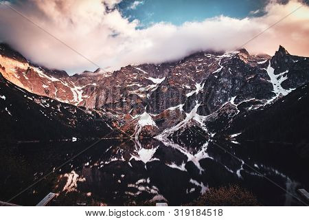 Breathtaking View To The Beautiful Mountains With Mirroed Reflection And Clouds At Sunset Time.
