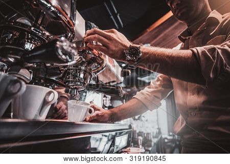 Talanted Barista Is Prepairing Coffee For Clients At Posh Restaurant Using Coffee Machine.