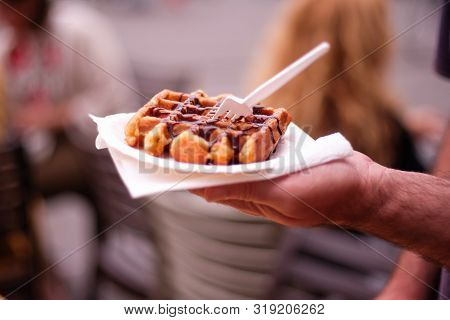 Hand Of A Man Holding A Waffle With Chocolate In A Street Of Ghent