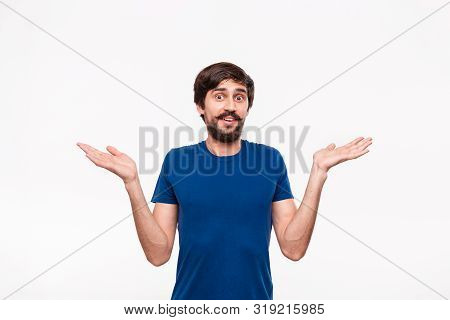 Good Looking Bearded Brunet Man With Mustaches Staches In A Blue Shirt Shrugging Shoulders With Scep