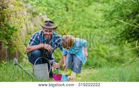 Dad Teaching Little Son Care Plants. Little Helper In Garden. Planting Flowers. Make Planet Greener.
