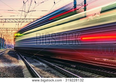 Passenger Train Moves Fast At Sunset Time.