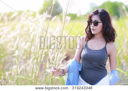 Young And Cute Girl Having A Happy Time And Enoying Amoung Grass Field In Nature