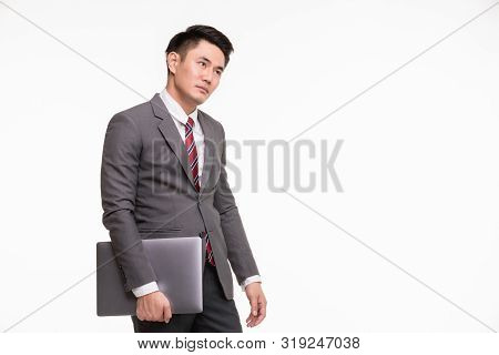 Handsome Asian Businessman Standing Putting Hand On Forehead And Holding Notebook Computer In His Ha