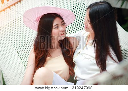 Young And Cute Asian Women With Hat Lying In A Hammock During Holiday