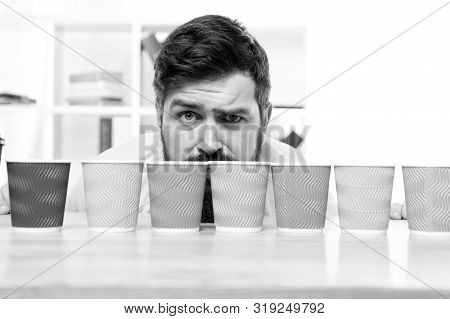 Difficult Choice. Decision-making. Serious And Sad Man With Colorful Coffee Cups. Many Cups Of Coffe