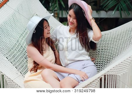 Young And Cute Asian Women With Hat Lying In A Hammock During Holiday