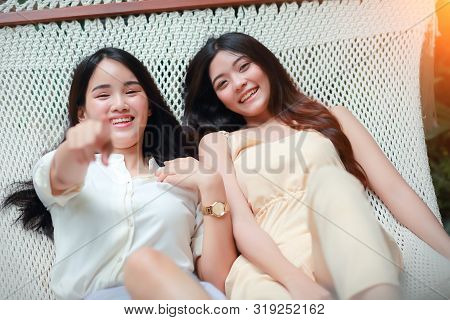 Young And Cute Asian Women Lying In A Hammock During Holiday