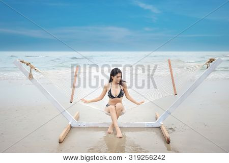 Sexy Asian Woman In Black And White Bikini Who Lying Or Sitting On Hammock On Sandy Beach With Beaut
