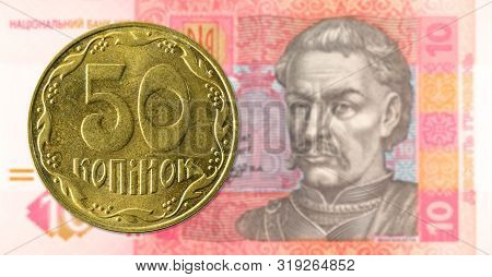 50 Ukrainian Kopiyka Coin Against 10 Ukrainian Hryvnia Banknote Indicating Growing Economics With Co