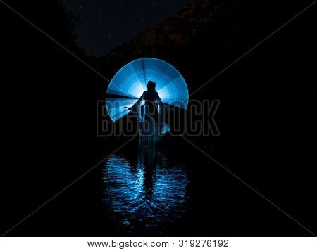 Nocturnal Photography, Lightpainting, Representing A Model In The River With Shadows Made With Lante