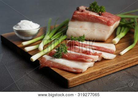 Board With Pork Fatback, Onions And Salt On Black Stone Background, Closeup
